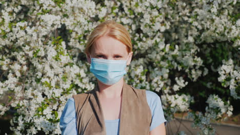 a man in a gauze bandage against a background of flowering trees allergy during the spring flowering