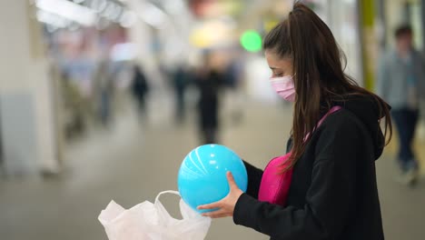 teenage girl shopping in a mall wearing a face mask