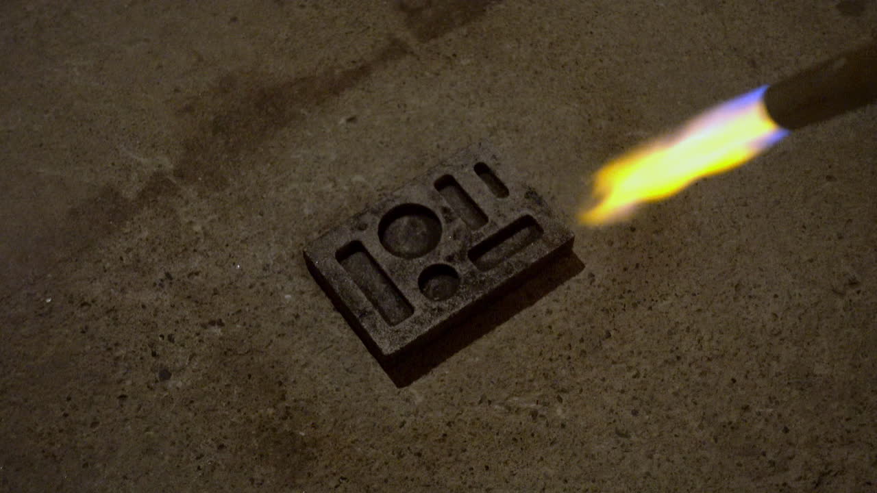 MAPP gas torch heats ingot mold in preparation for pouring molten metal