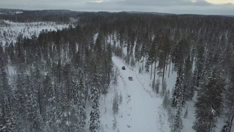 Cars-driving-through-a-snow-covered-landscape-near-Kuusamo,-Finland