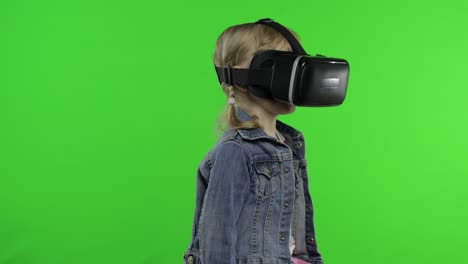 child girl using vr headset helmet to play game. watching virtual reality 3d 360 video. chroma key