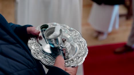 close up of silver tray with holy oils and cotton used for baptism in church ceremony