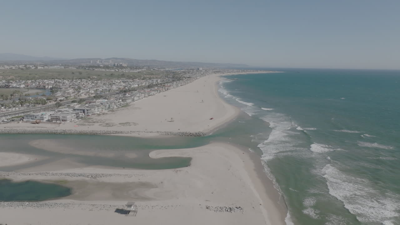 sobrevuelo aéreo de un río que ingresa al océano frente a una playa de costa mesa en california