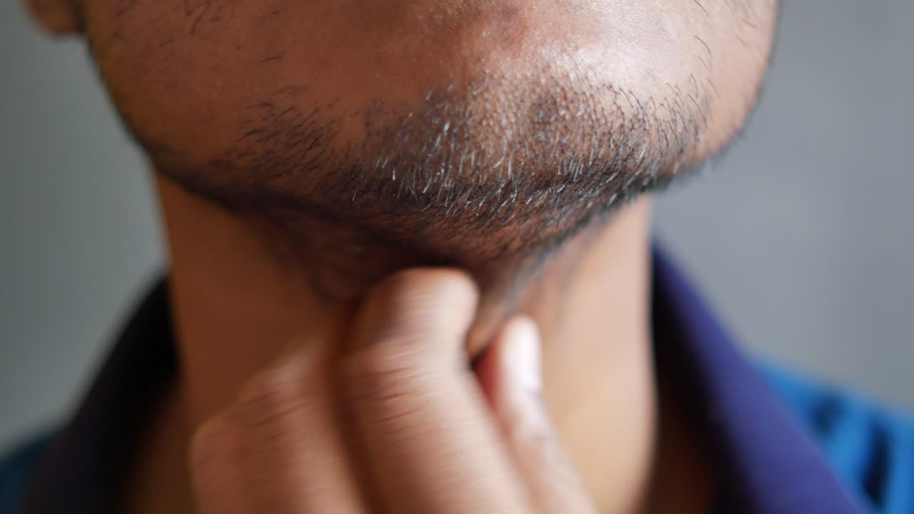 primer plano de un hombre tocando su barba