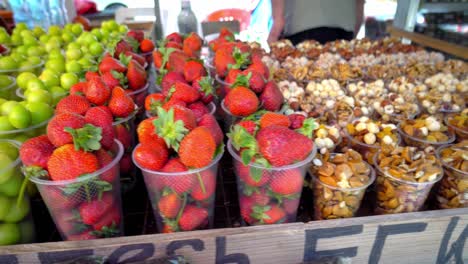 en el mercado de georgia, en vasos de plástico hay frutas secas, nueces,