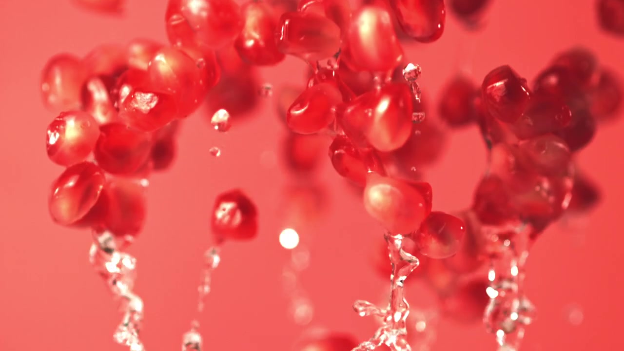 Fresh Pomegranate Seeds and Water Splashing in Slow Motion