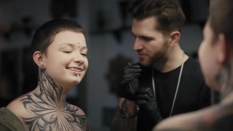 caucasian man and woman checking what the tattoo looks like after the tattooing.