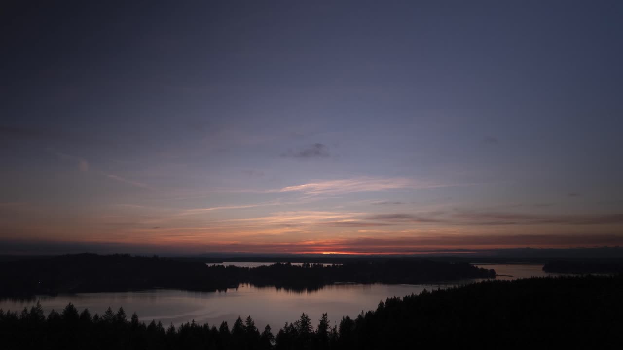 Beautiful high clouds reflecting in dark waters, epic golden sunset, aerial hyper lapse