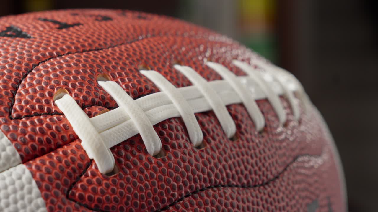 close-up von einem american-football-ball mit schnürsenkeln und einer textierten braunen oberfläche, statischer schuss