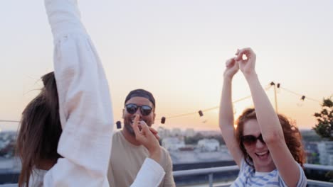 group of multi ethnicity friends dancing at the party in top of the roof.