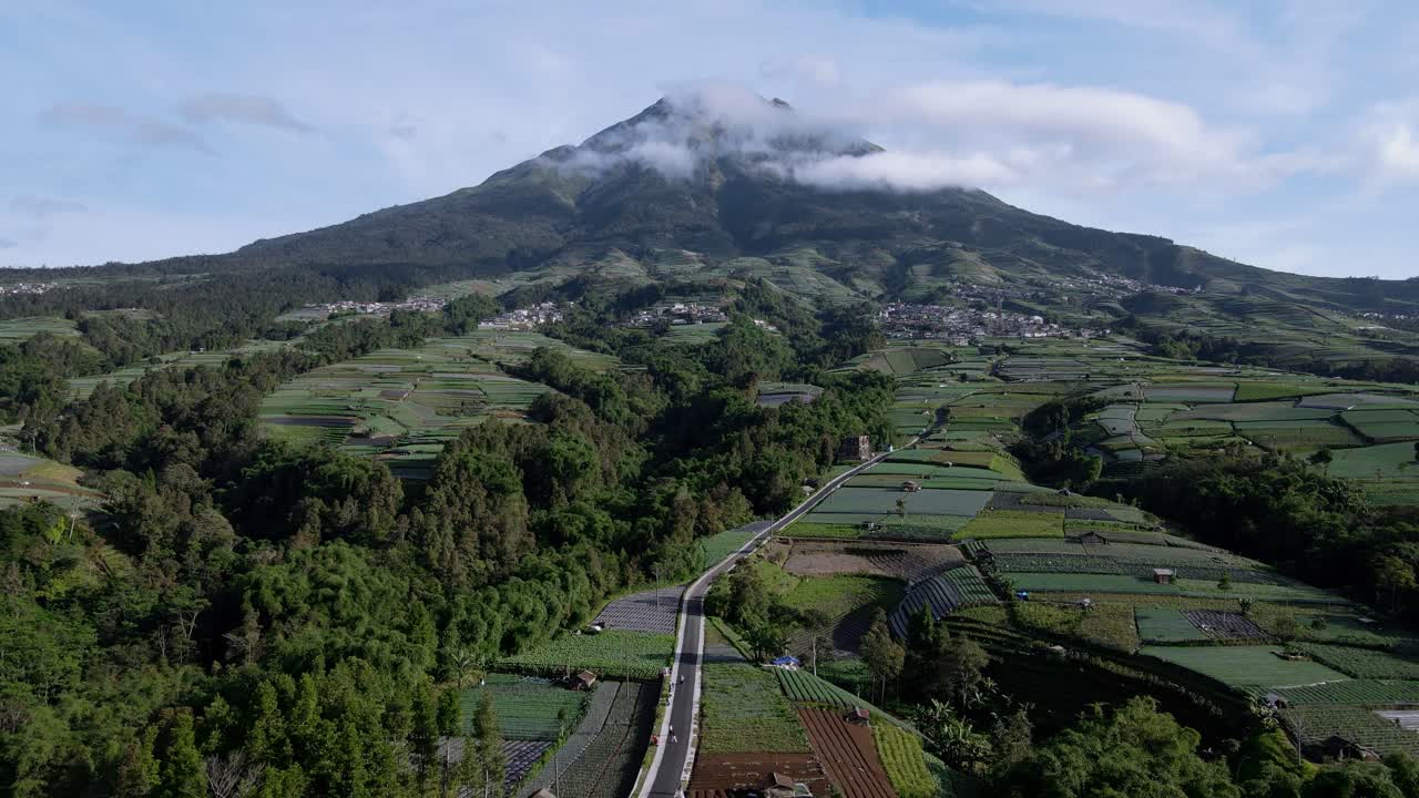 Sorvolo su un enorme campo agricolo con un bellissimo paesaggio montano