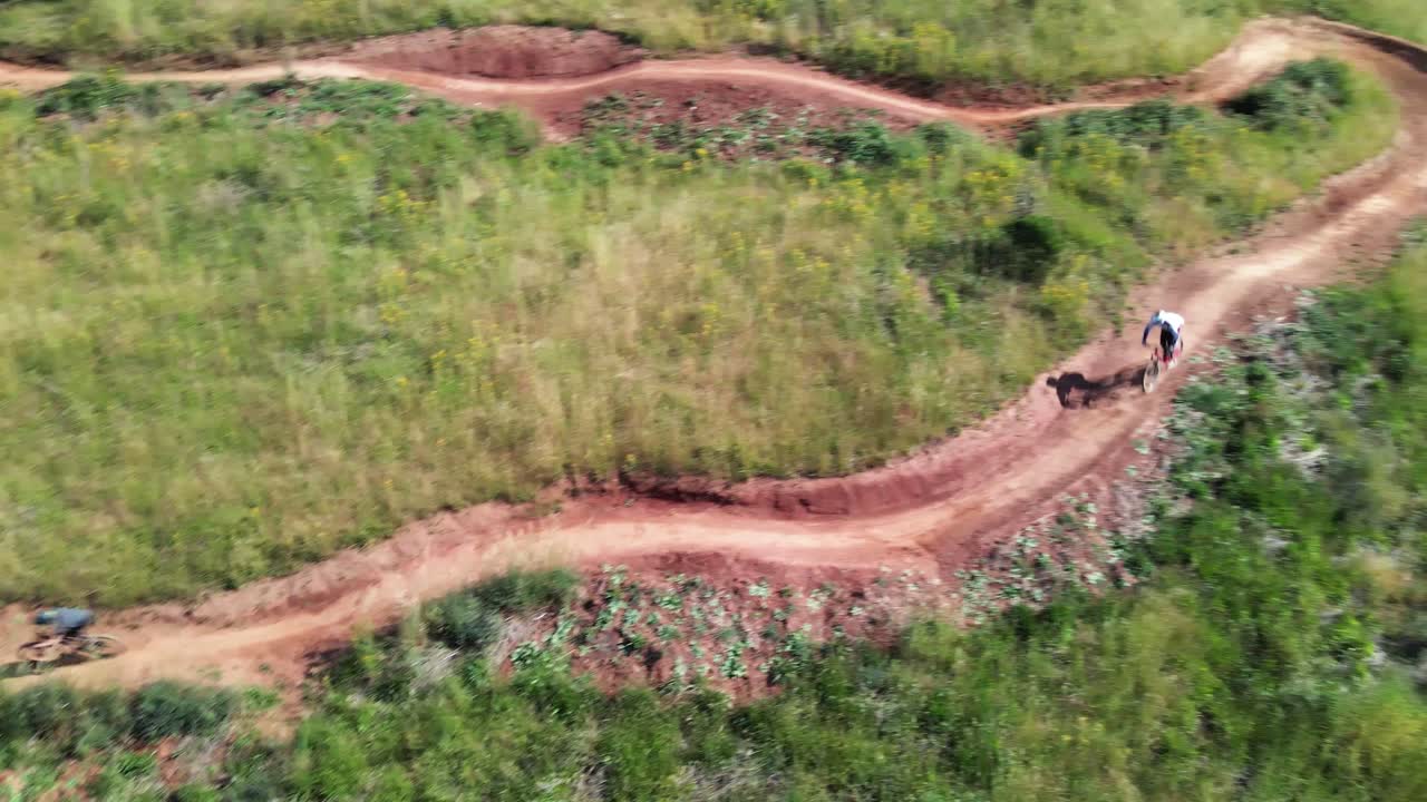 Mountain bike trail with rider riding down, drone top down shot-1