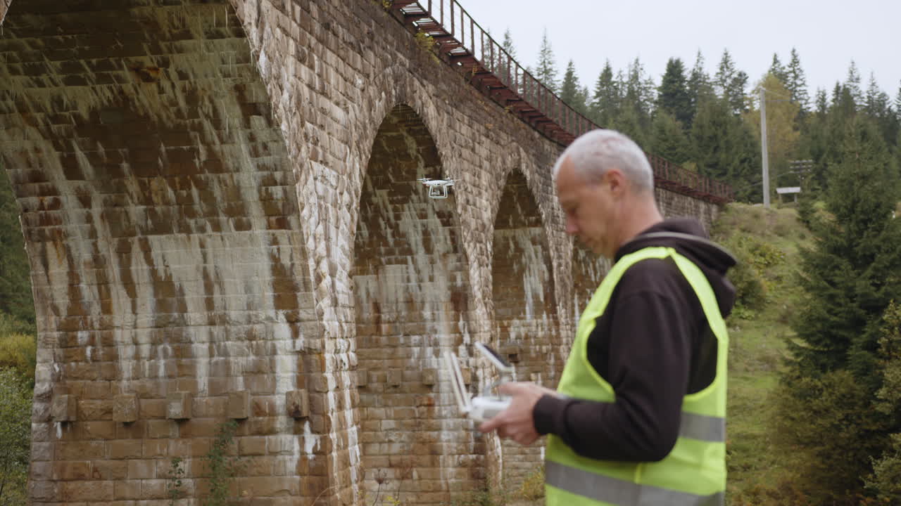 piloto de avión no tripulado operando control remoto cerca de un viejo puente de piedra