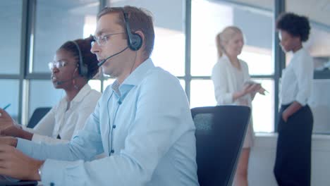 agentes de ventas diversos enfocados en auriculares que trabajan en el centro de llamadas