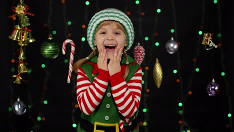 Niña-En-Traje-De-Ayudante-De-Santa-Claus-Elfo-De-Navidad-Riendo-Alegremente-En-El-Fondo-Con-Guirnalda