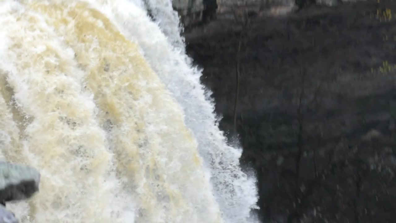 Tre vedute di una cascata a velocità normale. La cascata è grande, scorre rapidamente e mostra una potenza tremenda.