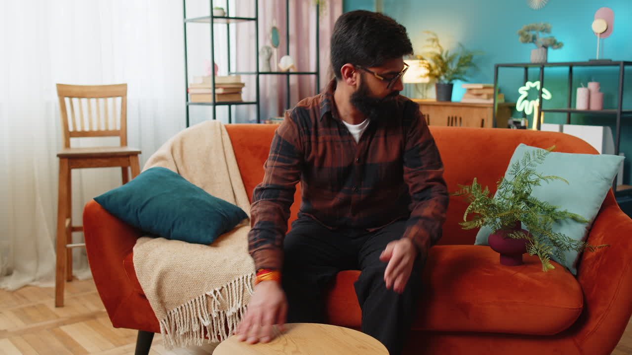 Happy indian man finishing assembling furniture table desk collect repair fixing at home apartment