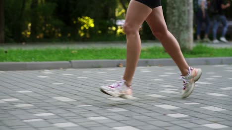 close up of female athlete's feet running at the park. fitness woman jogging outdoors. exercising on park pavement. healthy