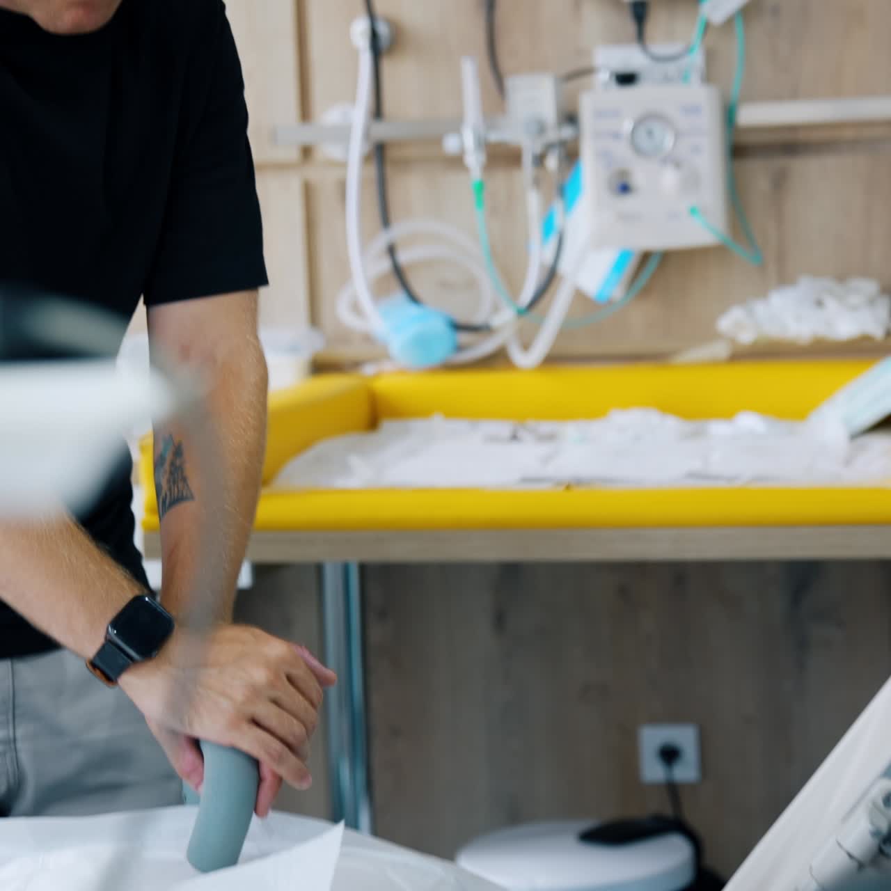 Worried Caucasian male in the hospital room with his wife delivering a baby. Concerned man looks down