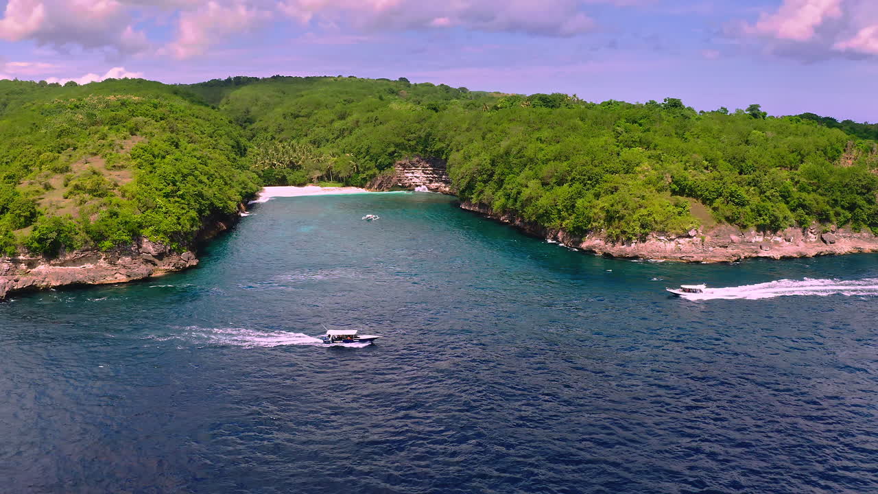 Motoscafi che navigano vicino a una laguna tropicale con spiaggia nascosta in una fitta giungla.
