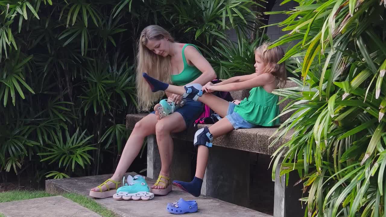 Mother and daughter putting on roller skates