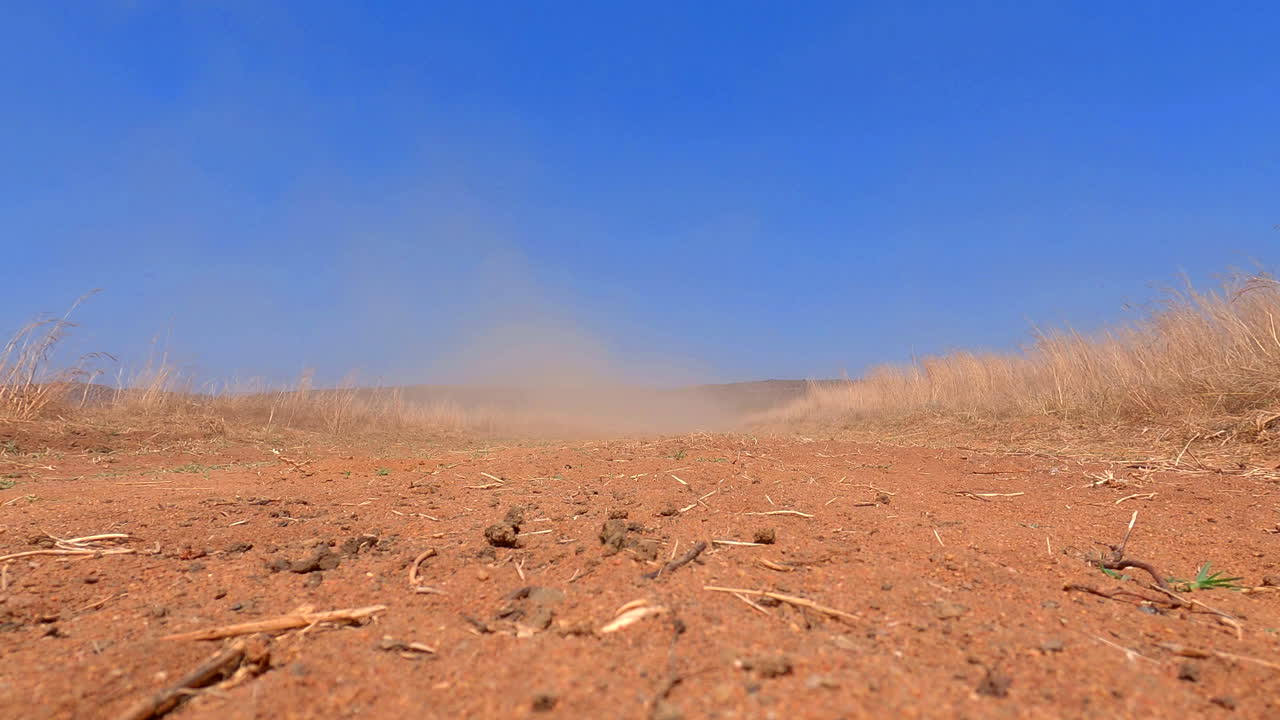 Low-Angle : Toyota Land Cruiser speeding through Africa's rugged terrain, leaving a cloud of dust behind