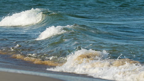 waves rolling onto shore under bright sunlight, capturing the essence of a sunny beach day