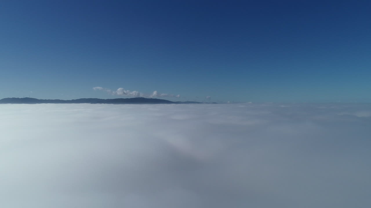 멀리서 아름다운 푸른 하늘과 구불구불한 언덕을 드러내는 흰 구름을 통해 드론 악센트
