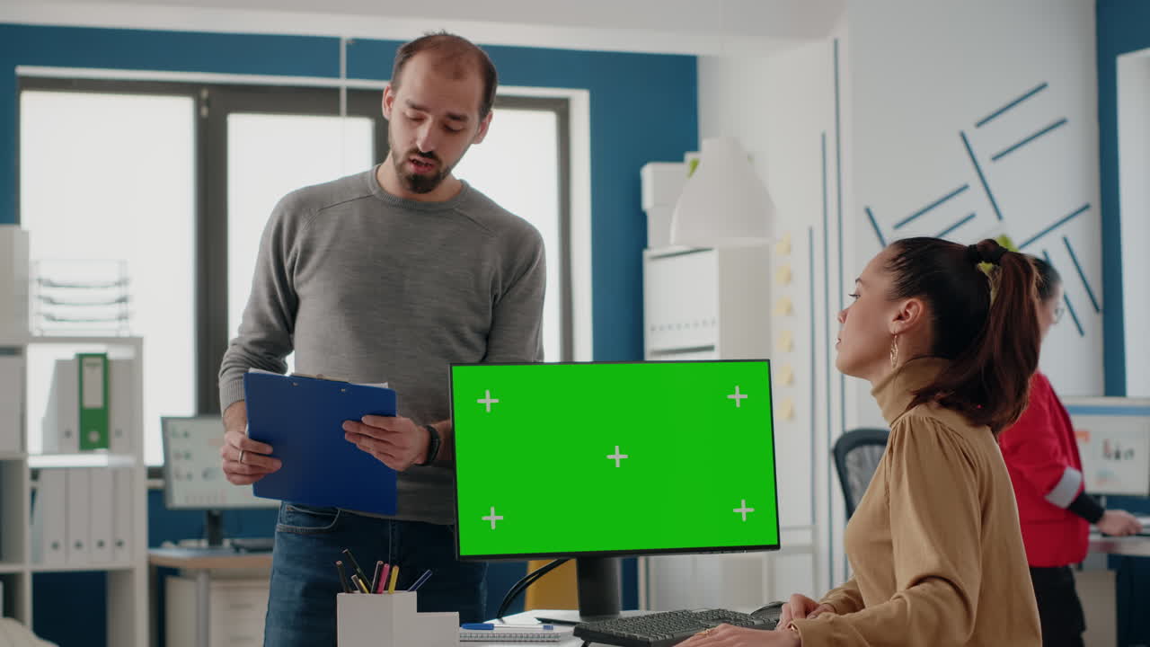 Team of colleagues working with green screen on computer