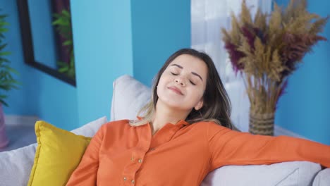 Relaxed-and-peaceful-young-woman-is-resting-on-the-sofa.