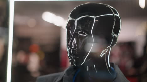 a close-up view of a black mannequin head with reflective neon outlines, capturing a sleek and modern aesthetic, the mannequin is set against a blurred background