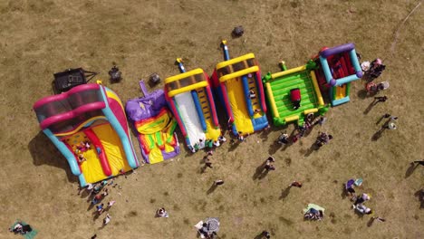 vista aérea de arriba hacia abajo de niños jugando en un parque inflable