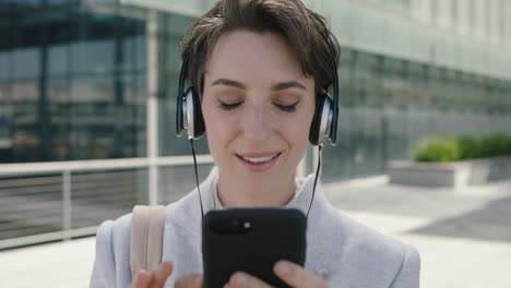 close up portrait of beautiful young business woman executive texting browsing using smartphone social media app enjoying music wearing headphones