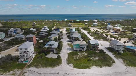 Aerial-approach-from-beach-as-cloud-shadows-fall-across-colorful-condos-in-Cape-San-Blas,-Florida