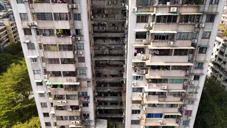 an old apartment building in guangzhou, china, with numerous air conditioning units on its exterior. a snapshot of residential living in an urban setting, highlighting the dense cityscape.