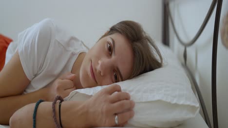 medium close up shot of a young woman waking up in the morning