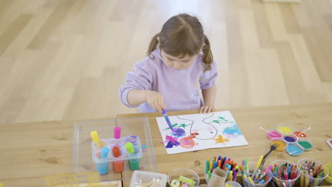 una chica en una clase de taller haciendo artes usando acuarela