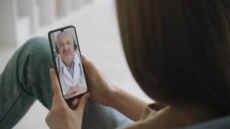 Frau-Nutzt-Medizinische-App-Auf-Smartphone-Und-Berät-Sich-Per-Videokonferenz-Mit-Dem-Arzt.-Frau-Nutzt-Online-Chat,-Um-Mit-Familientherapeuten-Zu-Sprechen-Und-Mögliche-Symptome-Während-Einer-Coronavirus-Pandemie-Zu-überprüfen.