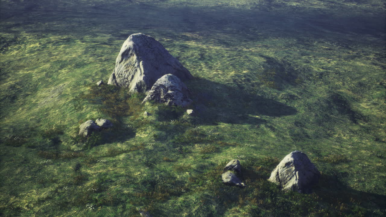 Large rocky formations on a grassy landscape under soft sunlight during daytime