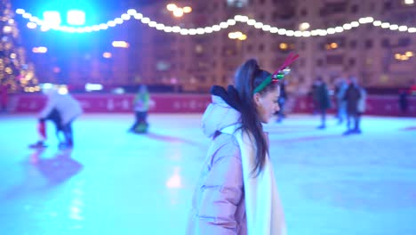 personas patinando sobre hielo en una pista de patinaje iluminada por la noche