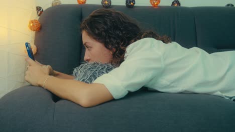 mujer relajándose en el sofá usando el teléfono