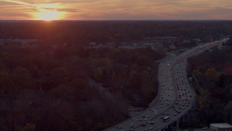 Luftaufnahme-Eines-Wunderschönen-Sonnenuntergangs-über-Bäumen-Und-Einer-Autobahn-Mit-Verkehr