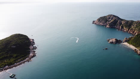 Aerial-forward-view-of-the-gate-of-Vinh-Hy-with-a-speedboat-turning