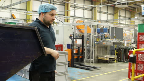 technician worker labor hiding from the boss chief while checking his smartphone during working shift hours inside modern factory