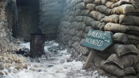 a walking wounded sign in a ww1 trench with sand bags and a troop fire next to a first world war dug out