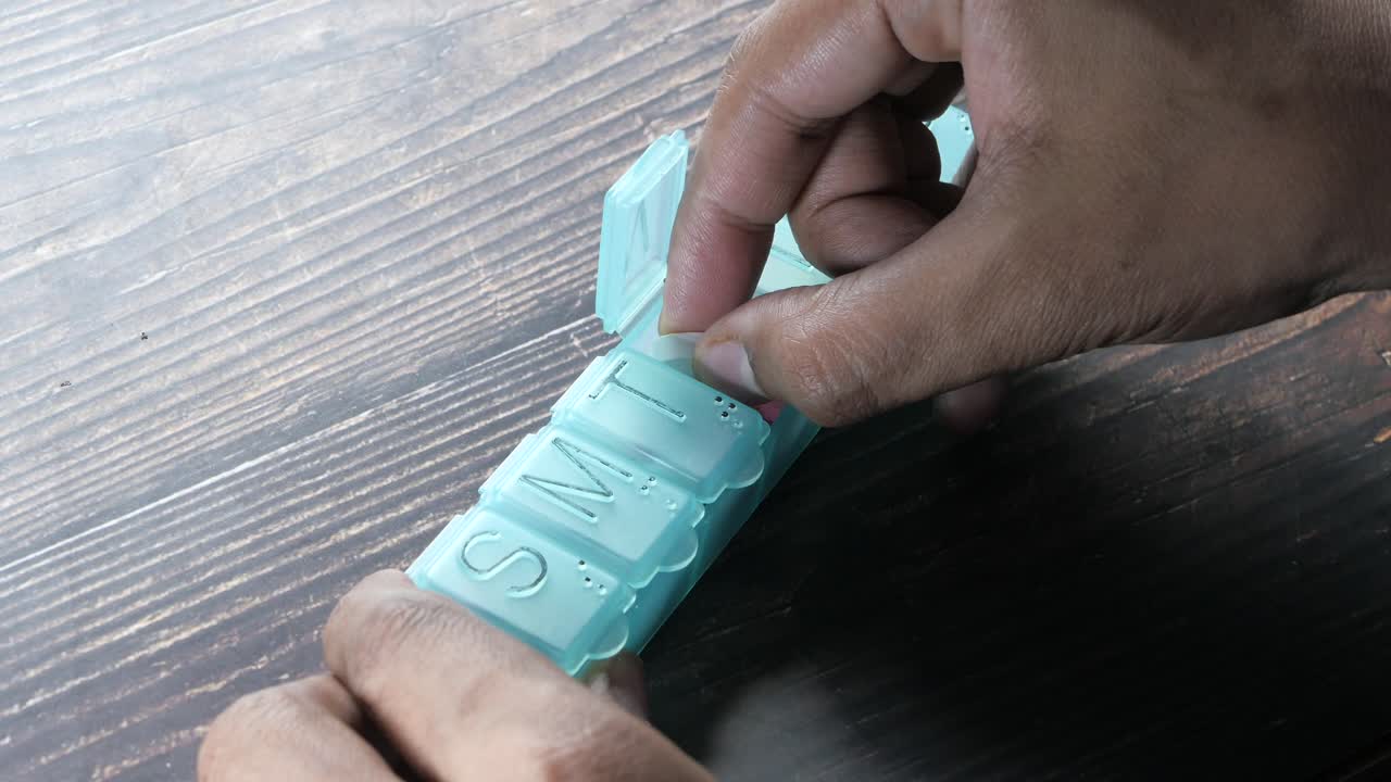 Person using a pill organizer