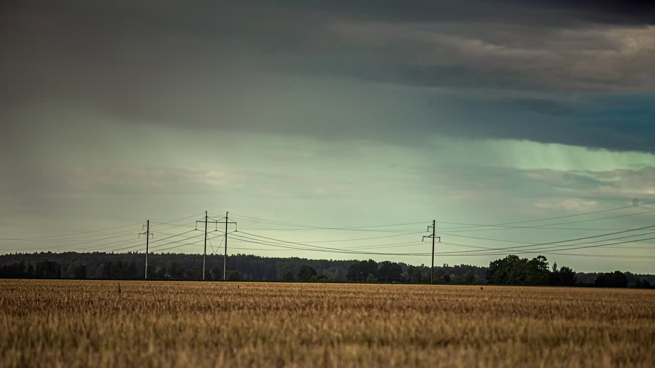 Static shot of rain cloud movement in timelapse above ripe wheat field along rural countryside on a rainy day