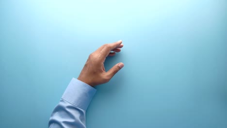 hands holding an empty cup of water on a light blue surface