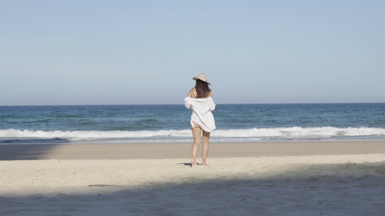 Girl at the beach, Beautiful young woman beachwear walking toward ocean