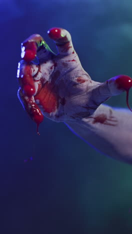 video vertical de manos cubiertas de sangre moviéndose sobre un fondo negro